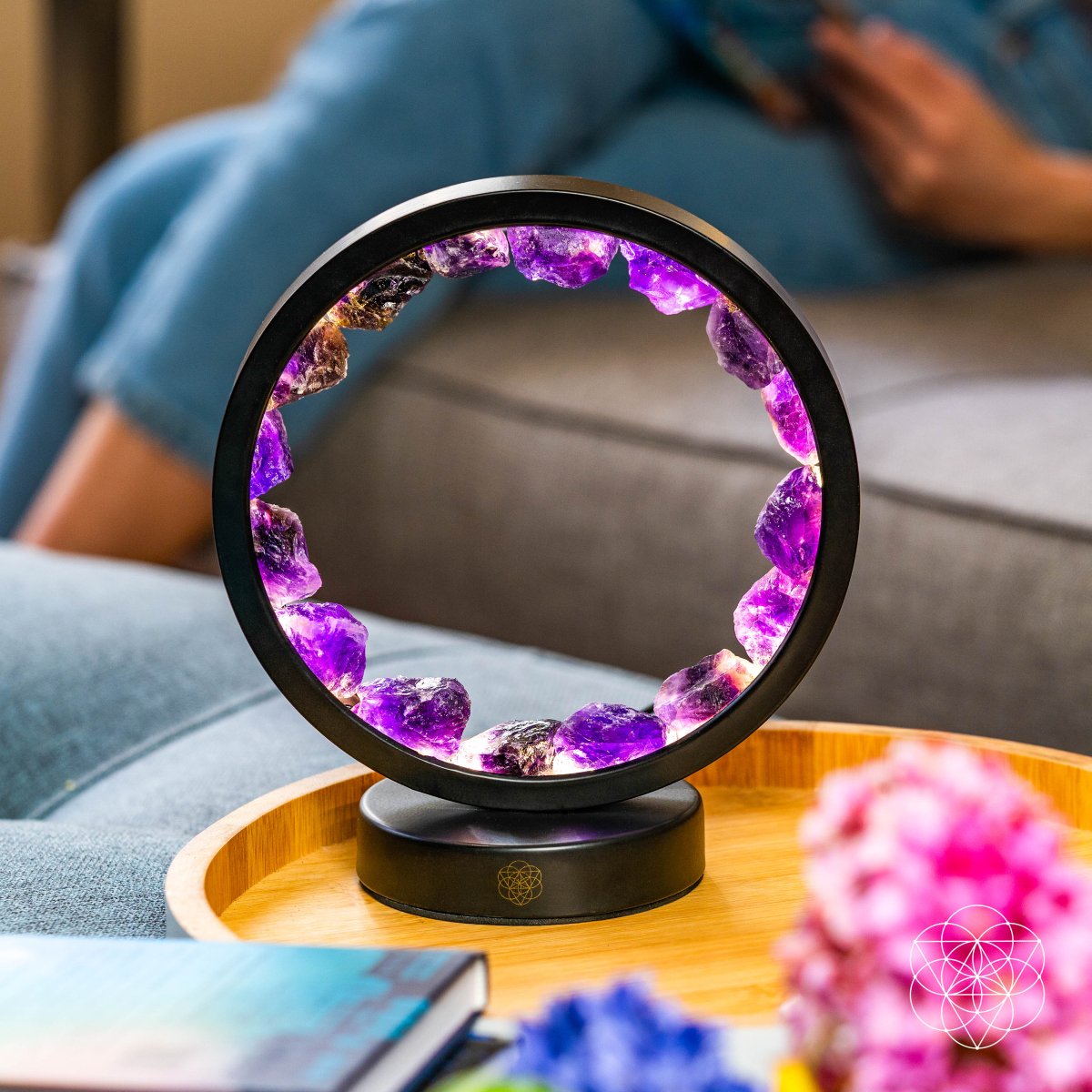 Amethyst Halo Desk Lamp on a coffee table beside a couch