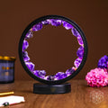 Amethyst Halo Desk Lamp lit on a wooden desk